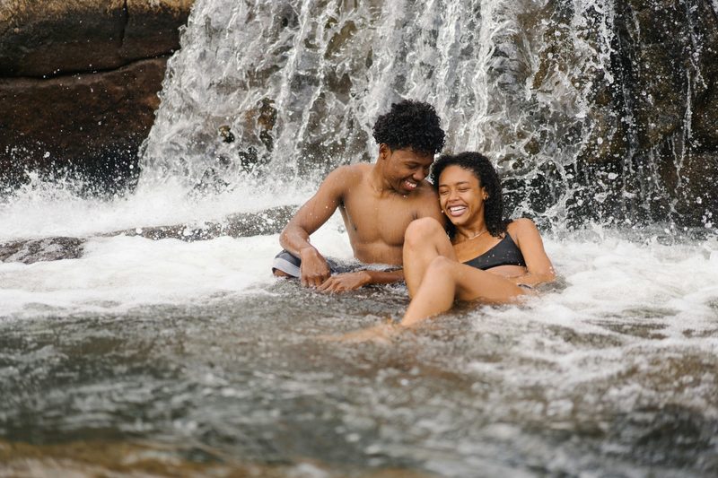 Couple relaxing under a waterfall